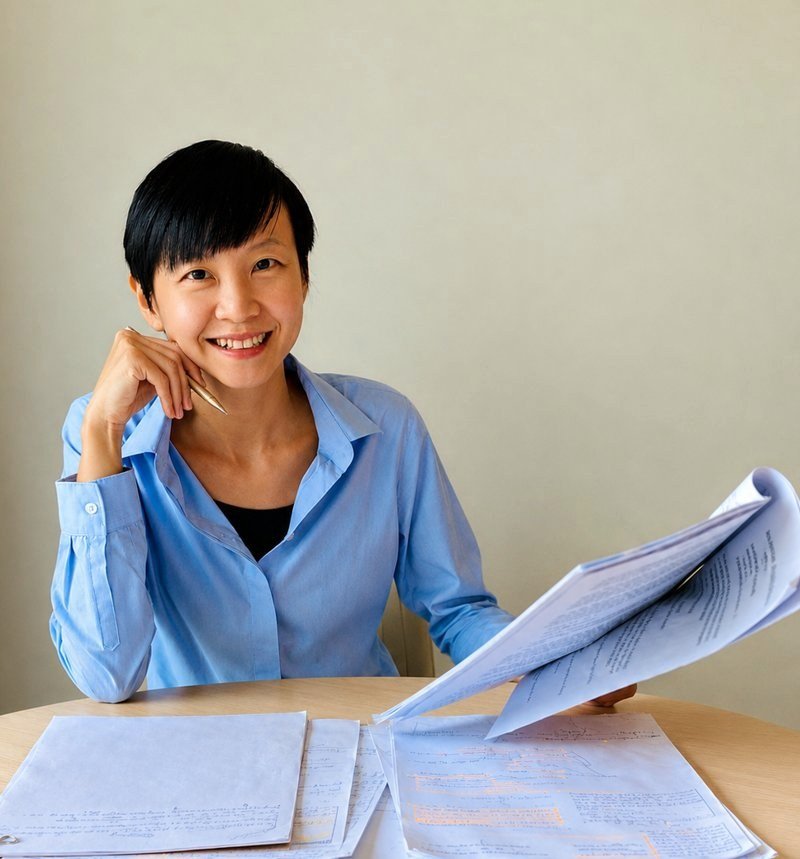 Trang Nguyen at her desk, reviewing handwritten notes and paperwork