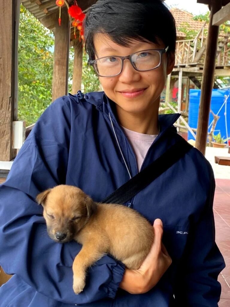 Trang Nguyen holding a sleeping puppy